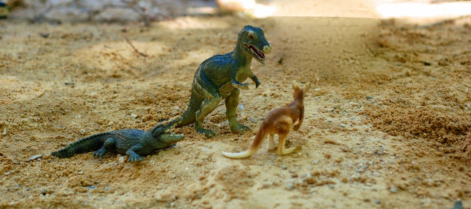 Figuras de dinosaurio, cocodrilo y canguro en tonos tierra cálidos, ambiente lúdico